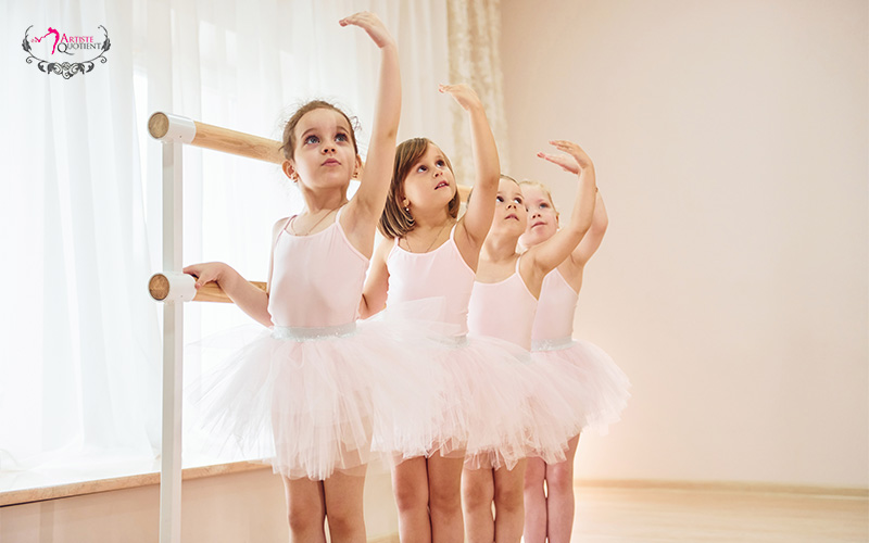 AQ Dance young students practicing ballet positions at the barre.