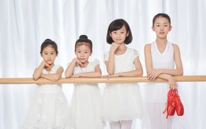 Four young ballet students posing at the barre.