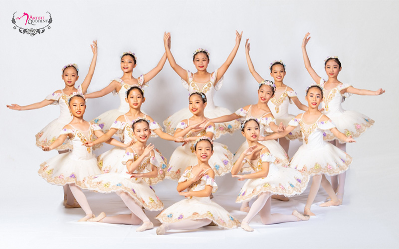 Group of young ballerinas posing in a dance studio.